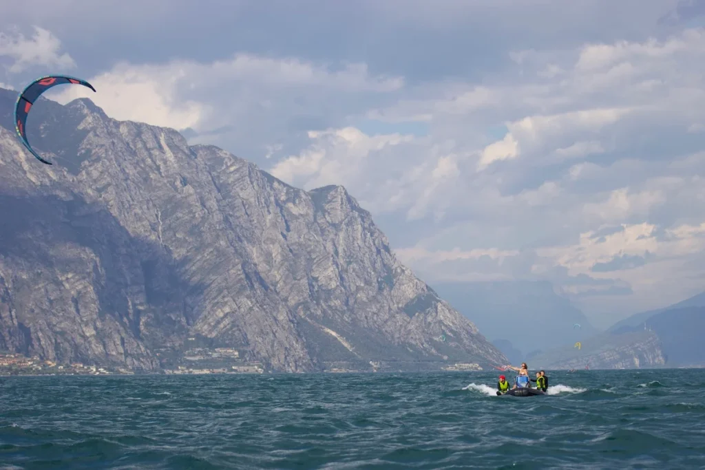 Boat with kite students on Lake Garda during a beginner kiteboarding course, capturing the dynamic and educational experience of learning the sport against the stunning backdrop of the lake.