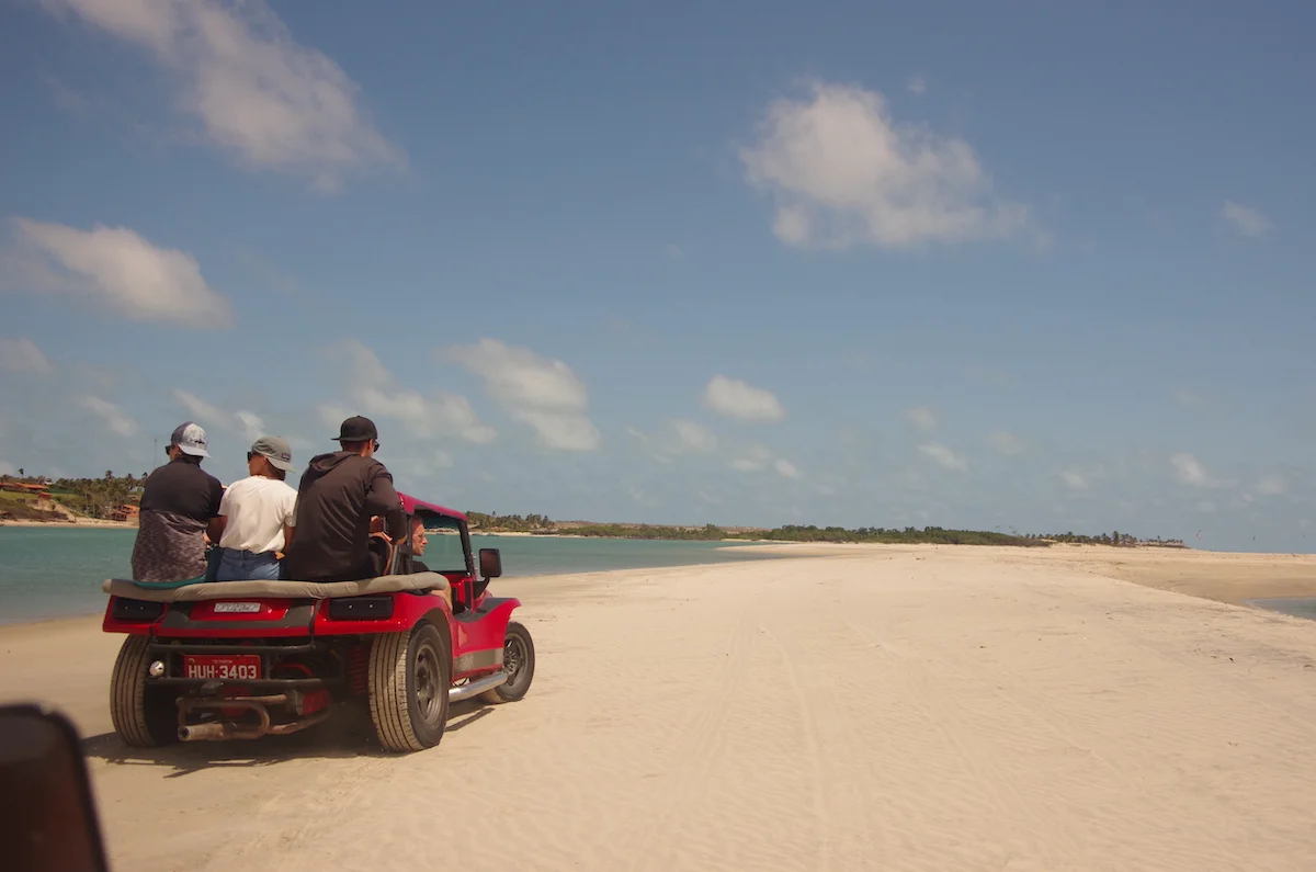 Adventurous buggy tour through the breathtaking dunes of Brazil, with the sandy landscape stretching far and wide under the open sky.