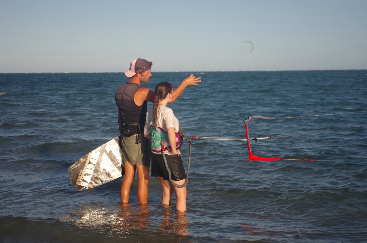 Kitesurf instructor giving tips to he's student in a beautiful lagoon of brazil during a kitevoyage kitecamp