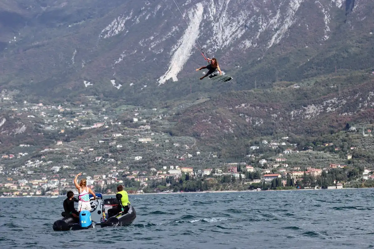 Kitesurfer instructor jumping over a boat to show all the student he's skills