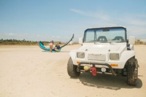 Beach buggy and kitesurfer preparing a kite for the upcoming session in Brazil with kitevoyage kitecamp