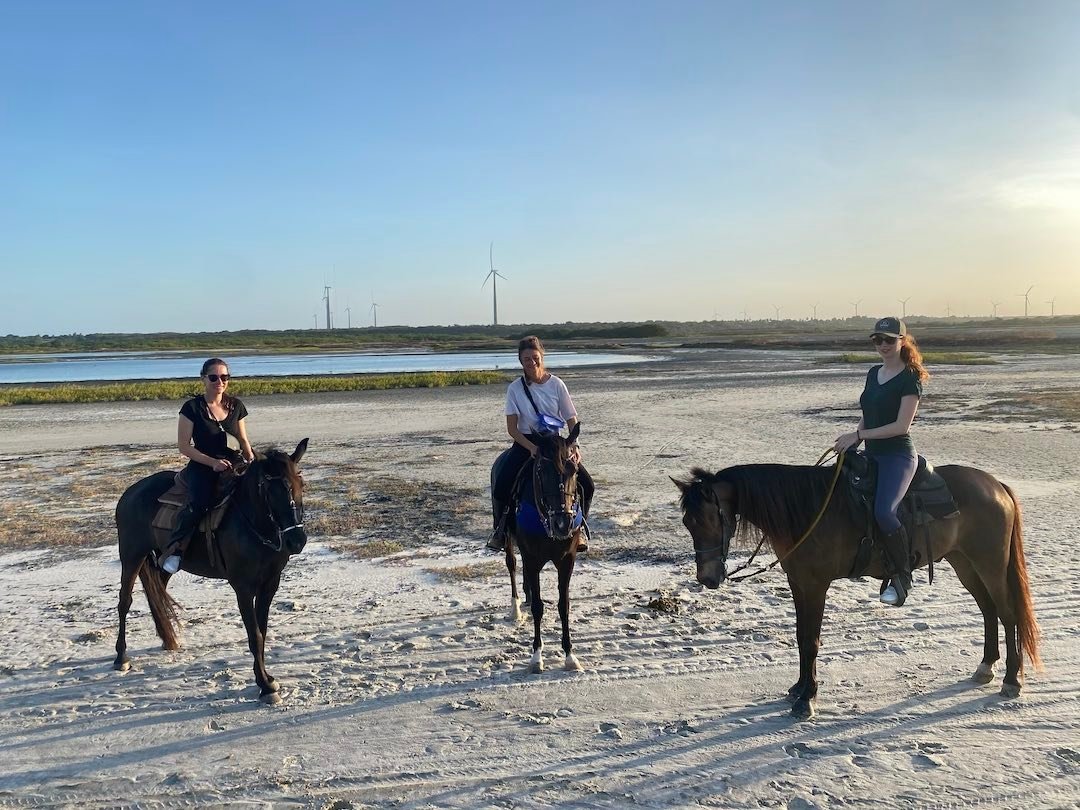 group picture of girl riding horse in Brazil and enjoying the endless jungle and sand dune. during kitevoyage kitecamp