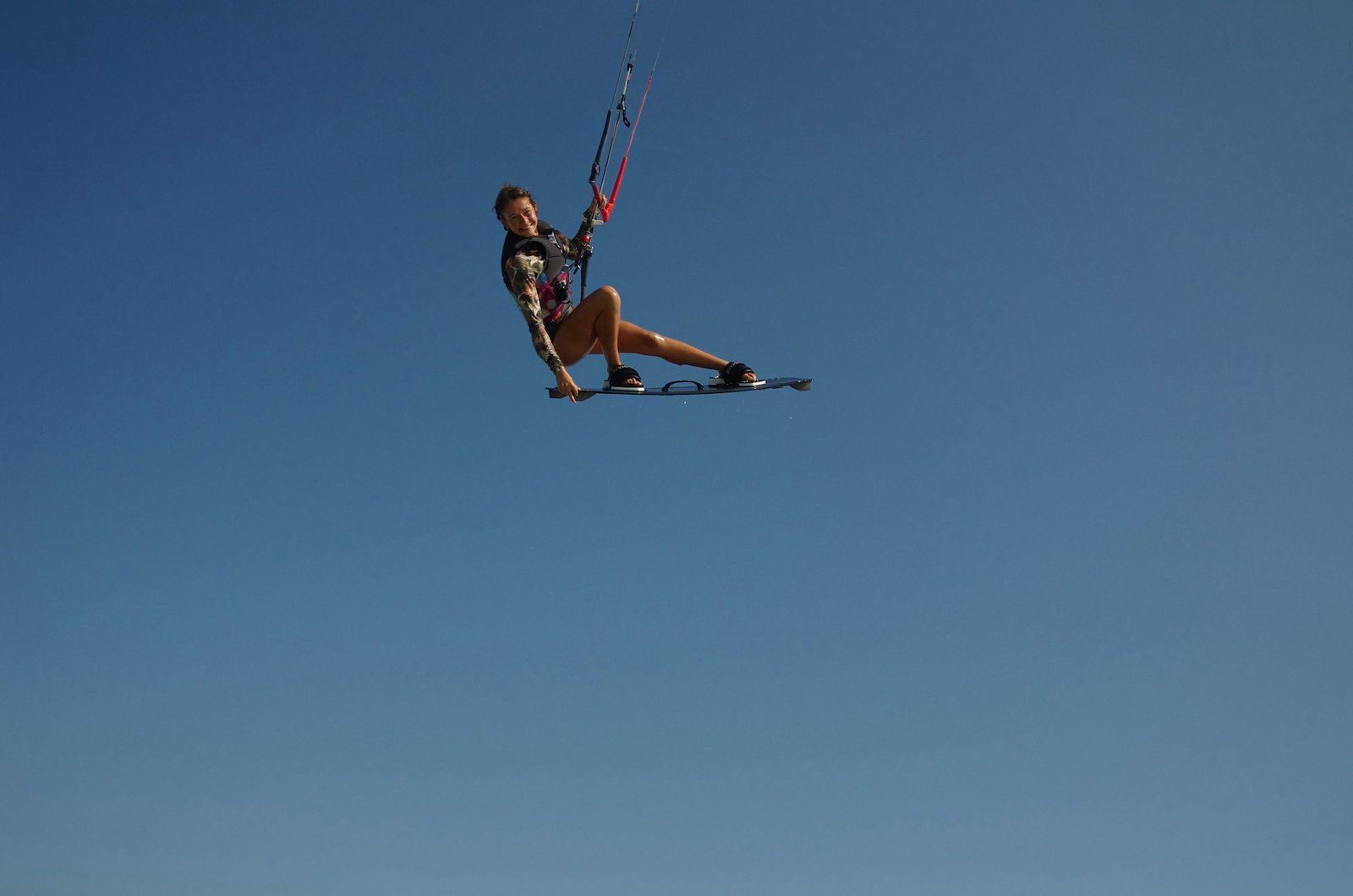kitesurf girl jumping into the the sky during her kitersurf session in brazil with kitevoaye kitecamp