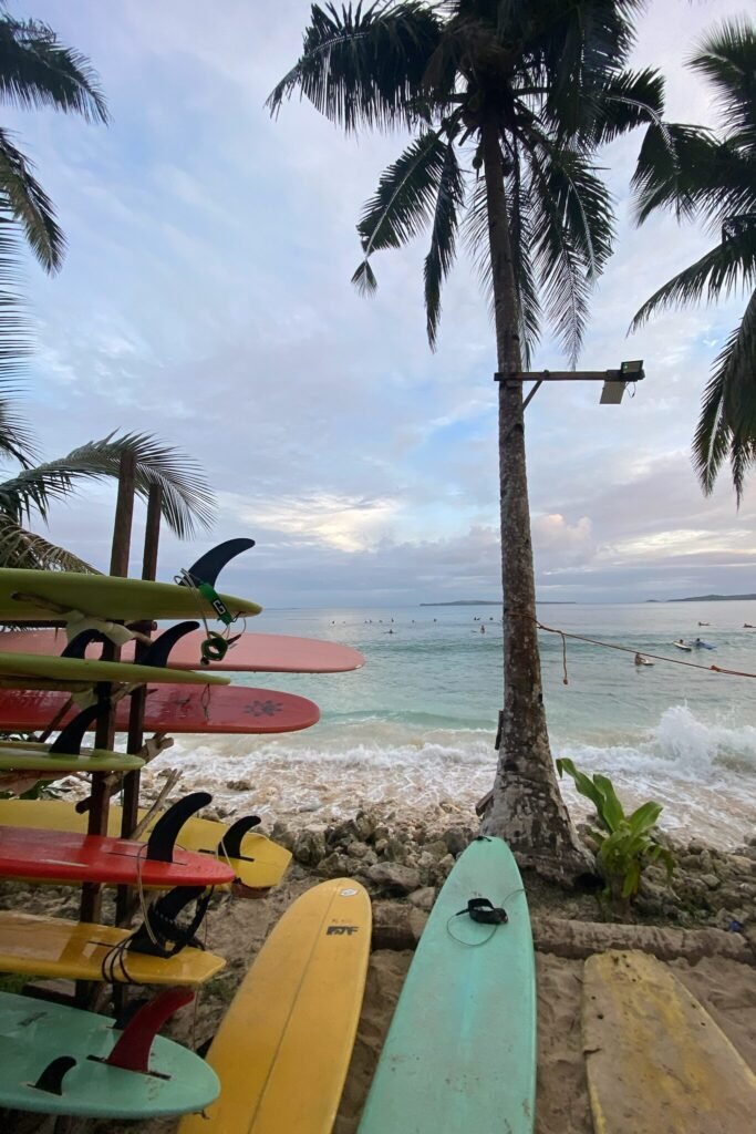 Surfboard on a rack, framed by the captivating beauty of a picturesque surf spot in Siargao, Philippines, inviting enthusiasts to embrace the waves and tropical charm.